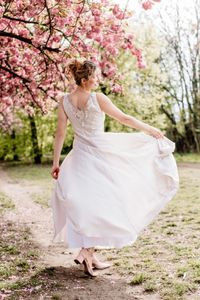 Brautkleid und Abendkleid aus hauchd&uuml;nnen, flie&szlig;enden Stoffen mit Blumen, Silber, Perlen und einer schwingenden Silhouette